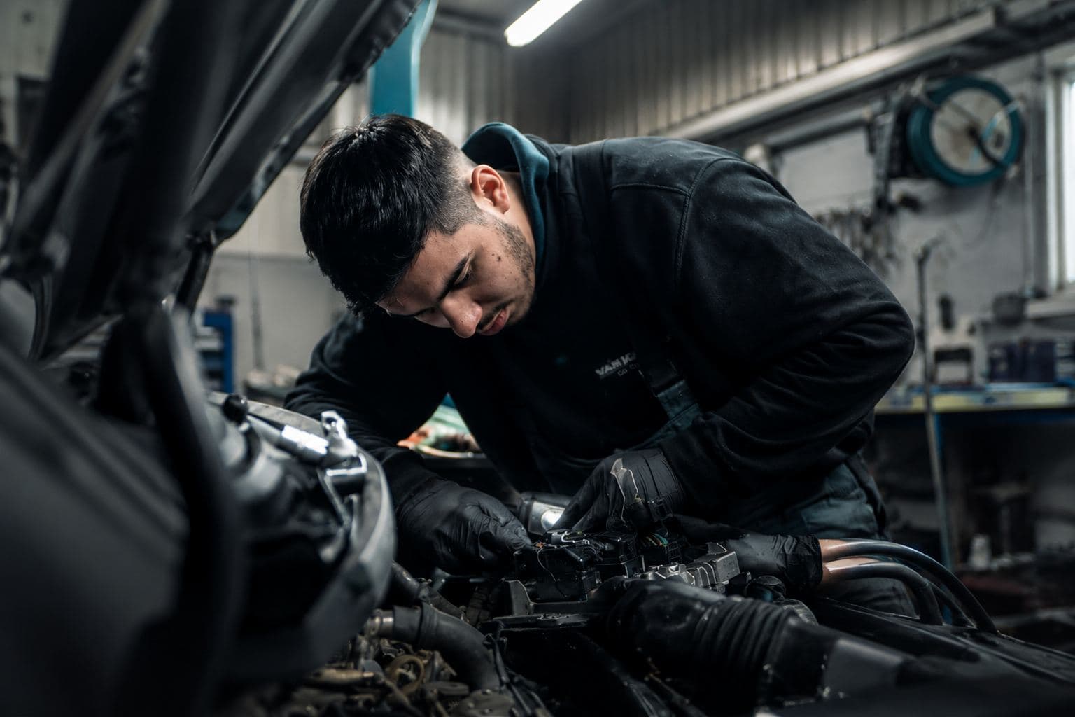 Mechanic repairing a vehicle engine for MyDrive roadside assistance