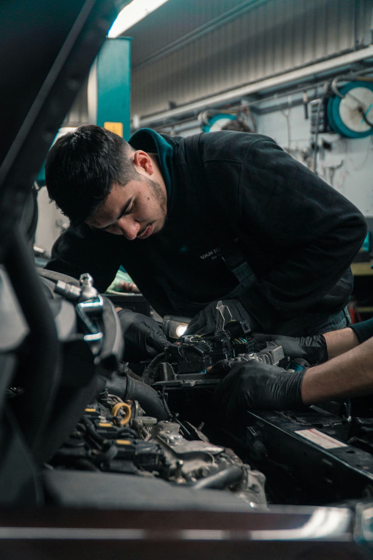 Mechanic working on a vehicle engine in a repair workshop