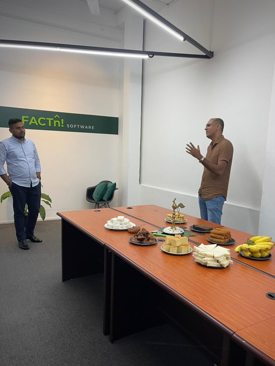 FACTn team members speaking beside the New Year treats at the office