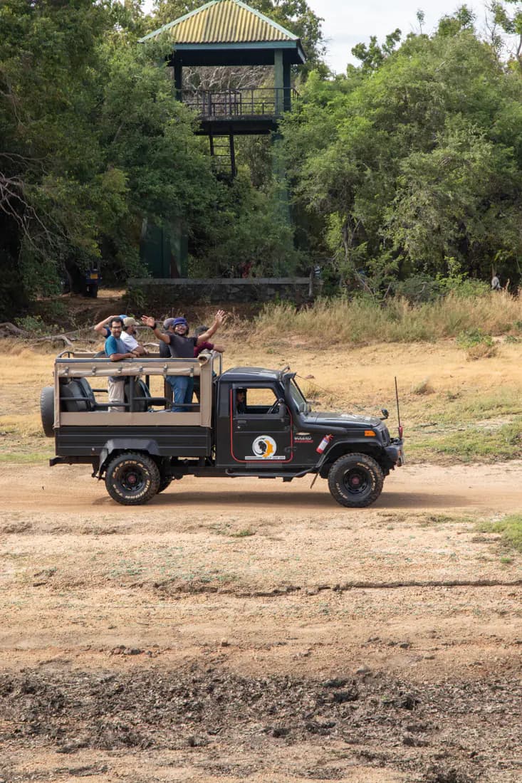 A safari jeep carrying the FACTn team past a forest observation tower