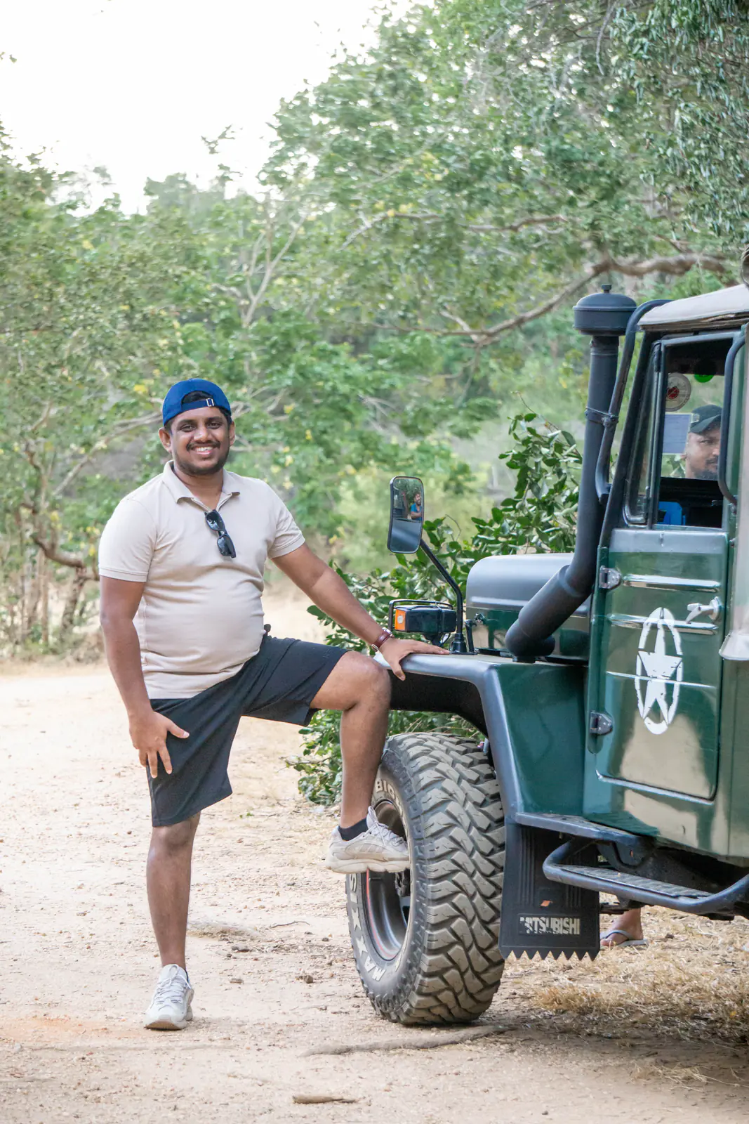A man posing beside a safari jeep at Minneriya