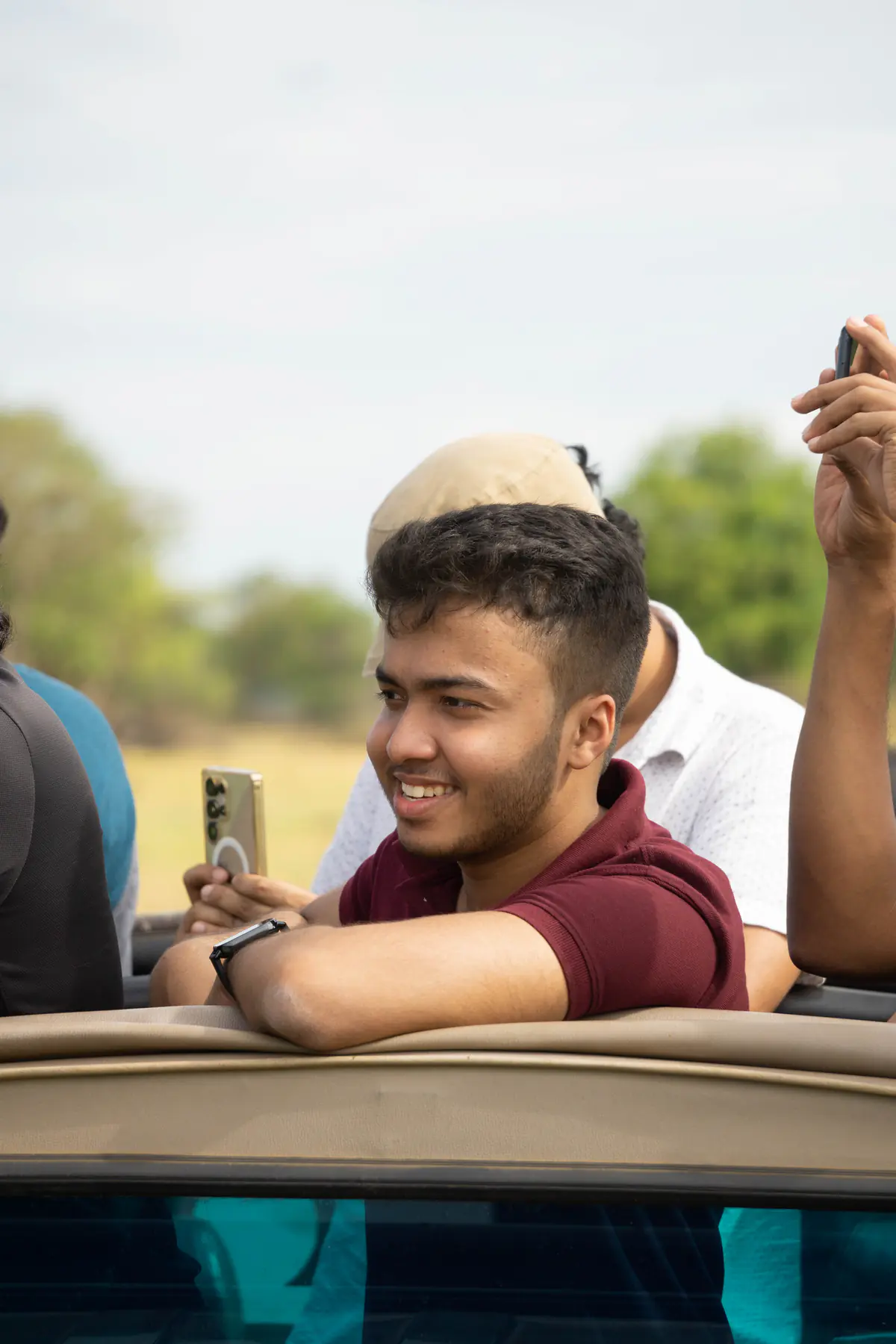 A man photographing the view from a safari jeep at Minneriya