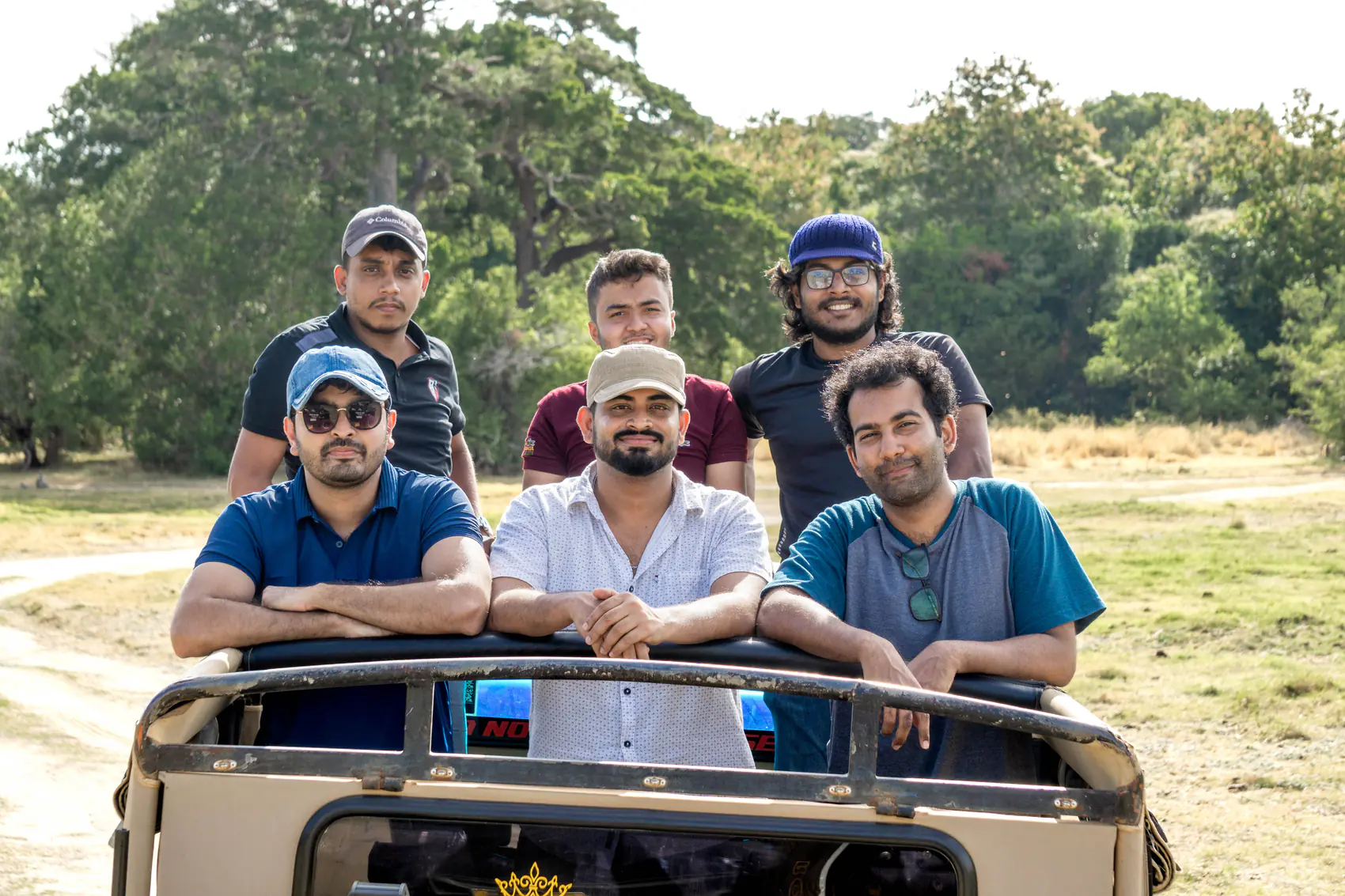 Five FACTn team members posing together in a safari jeep