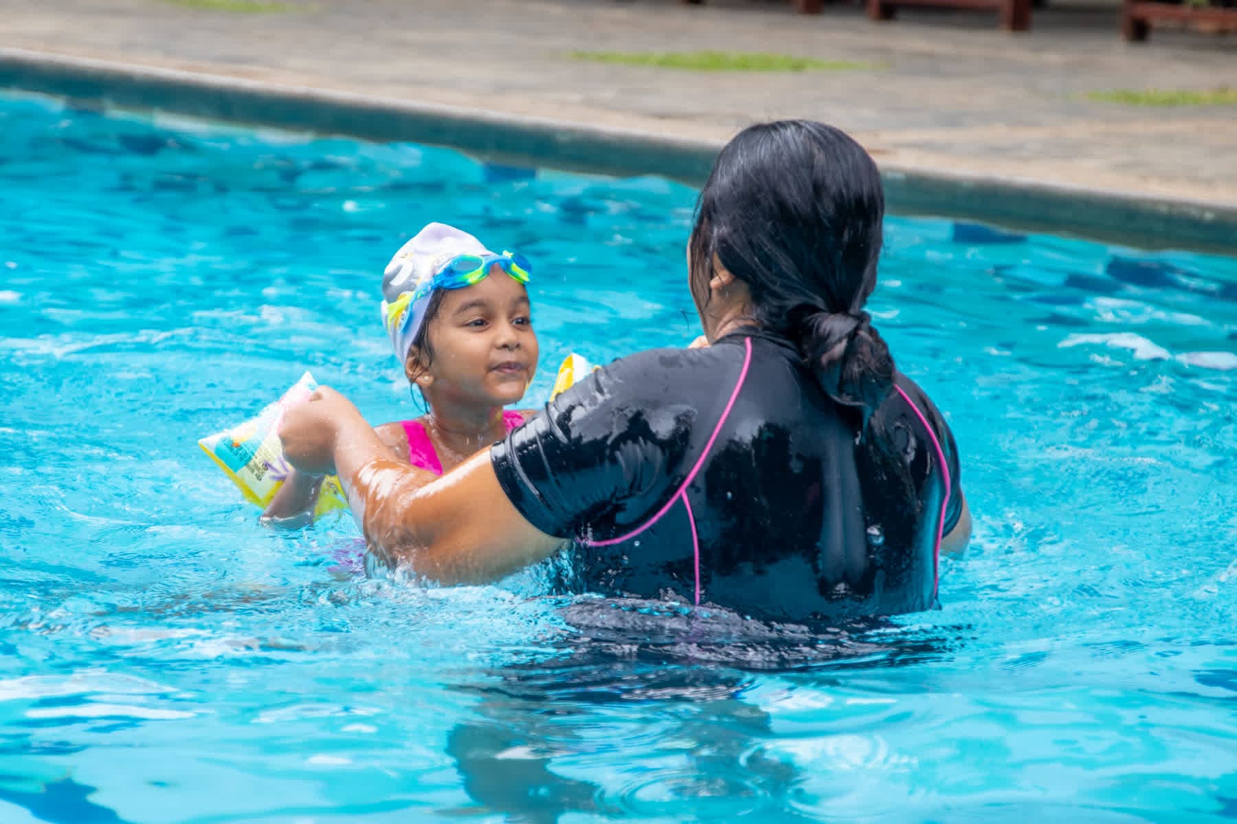A parent and child swimming together at Hotel Sigiriya