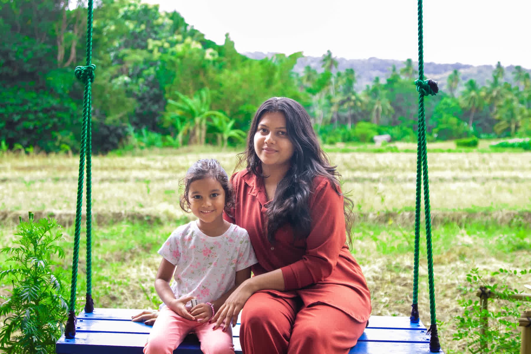 A mother and daughter sharing a garden swing at Hotel Sigiriya