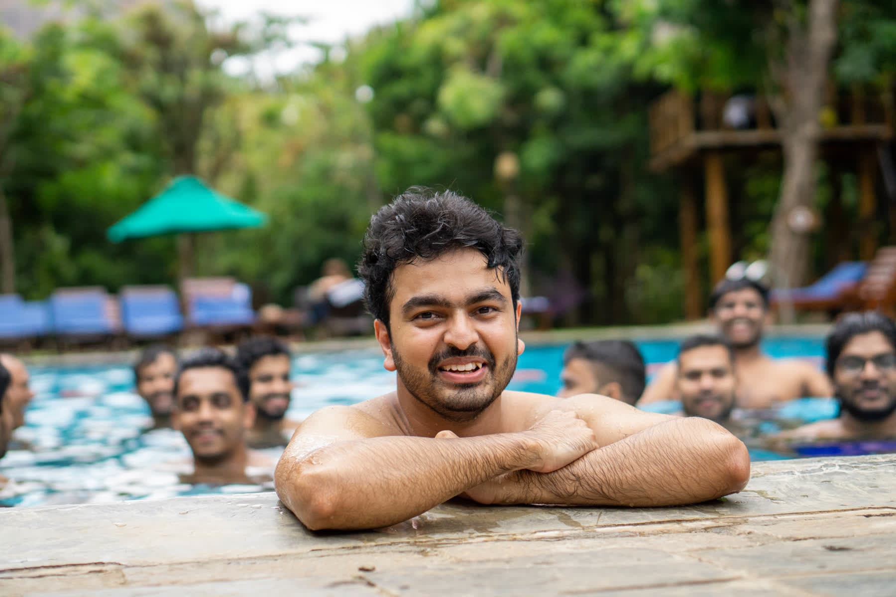 FACTn colleague relaxing at the Hotel Sigiriya pool with teammates behind him
